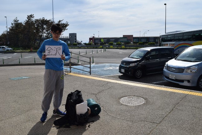 ヒッチハイクをする大学生