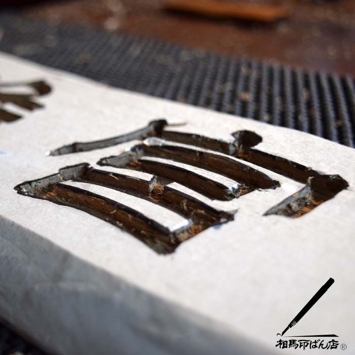 ノミで刻す木製の看板