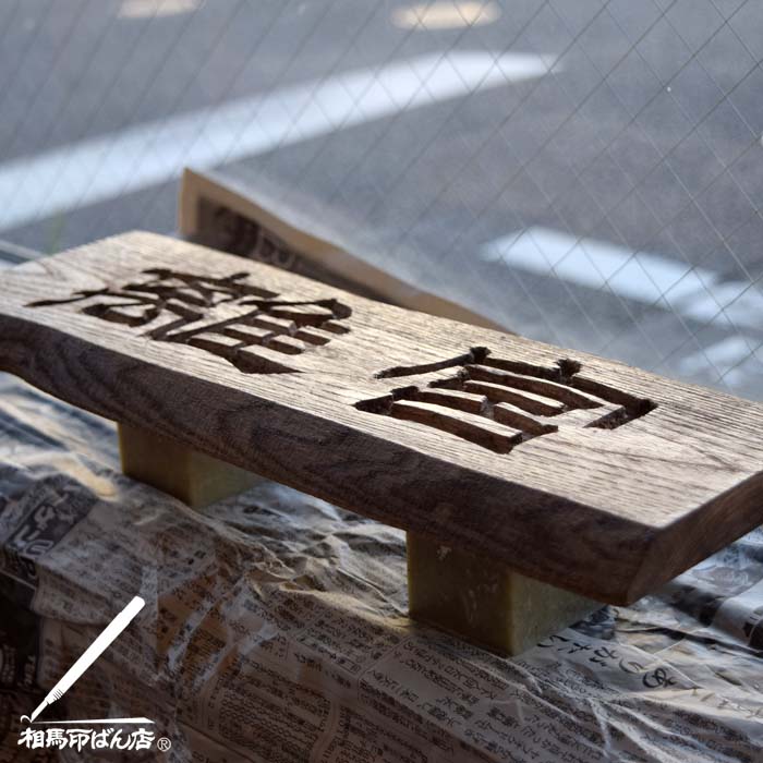 刻字でつくった木製の看板にニスを塗る